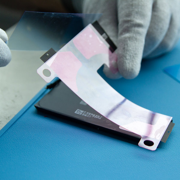 Lepljenje novega lepilnega traku na novo baterijo